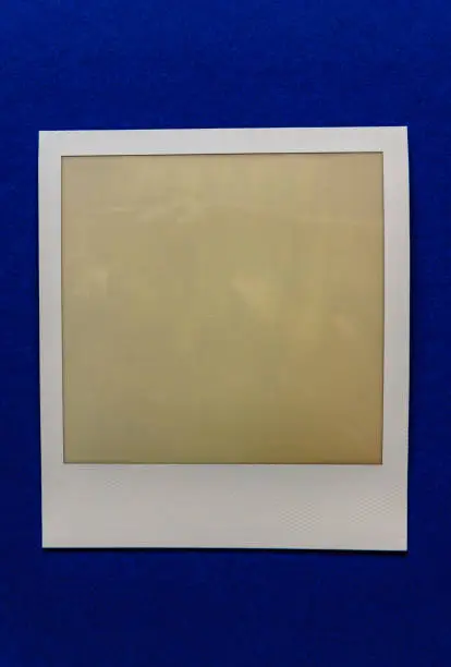 Photo of old empty instant film frame on real paper background