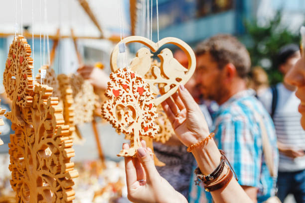 una turista donna a una fiera di souvenir scegliendo regali decorativi fatti a mano in legno - craft product foto e immagini stock