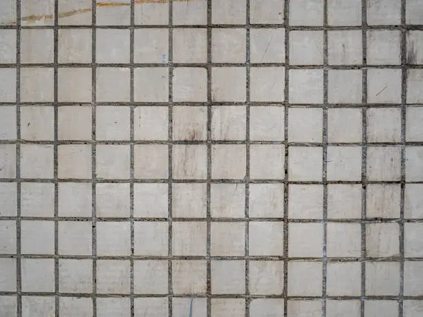 Photo of Old ceramic tiles on the wall of the house. Dirty mosaic