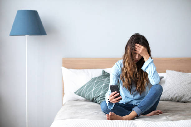 istock Upset woman with smart phone at home on the sofa. 1145602964