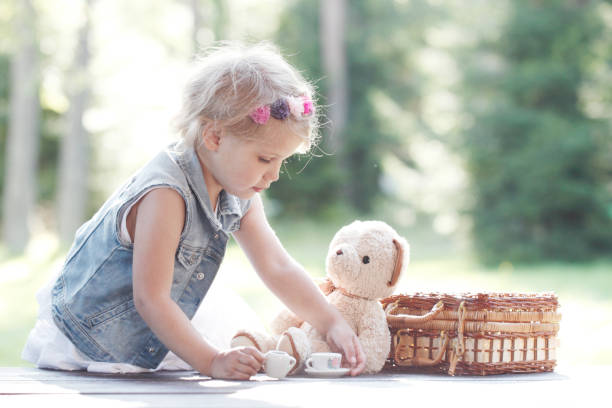 istock Girl playing with teddy bear 1145606517