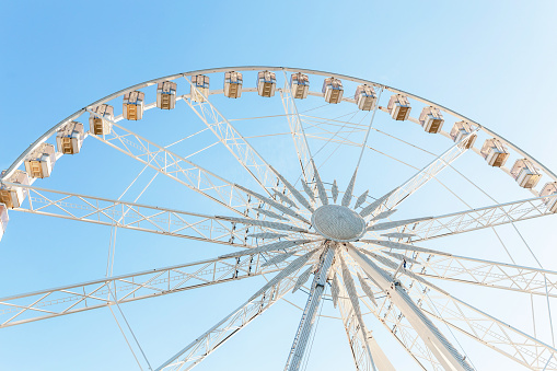 White Ferris Wheel Over Blue Sky and sunshine