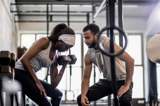 istock Woman Training Weight Lifting With an Instructor 1145610039