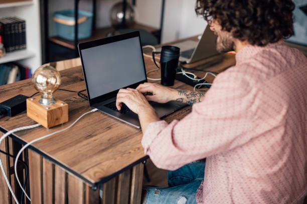istock Millennial man working on a laptop and using charging station for his phone 1145618515