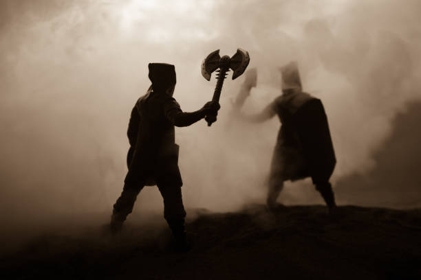 istock Medieval battle scene with cavalry and infantry. Silhouettes of figures as separate objects, fight between warriors on sunset foggy background. Artwork decoration. Selective focus 1145618761
