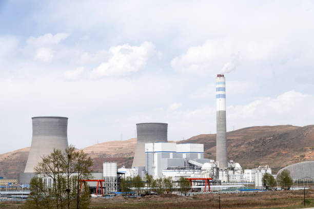 The power plant is set against a blue sky and white clouds