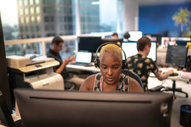 Businesswoman wearing headset in office callcenter