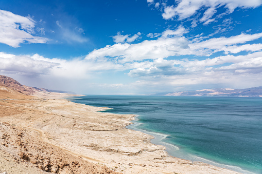 Beautiful scenic view from above along the dry rocky Dead Sea Coast of the West Bank Israel. Jordan Dead Sea Coast on the horizon. Dead Sea, Ein Gedi, Israel, Middle east.