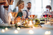 A big family sitting at a table on a indoor birthday party, eating.