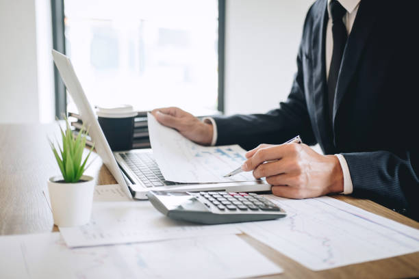 istock Businessman working new project on laptop computer with report document and analyze, calculating financial data on graph documents, doing finance making notes statistics 1145625226