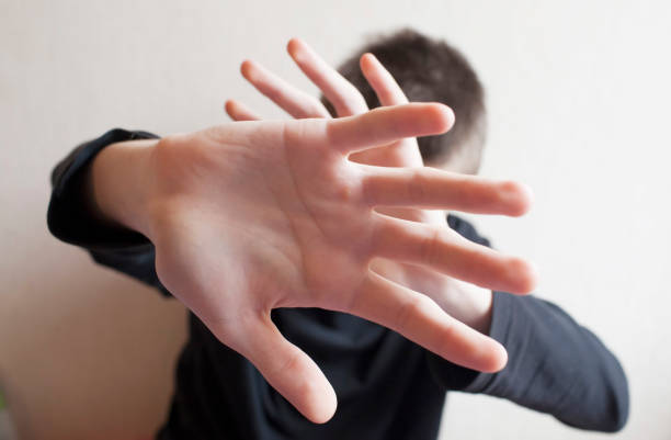 istock Teen boy protects himself with open palm 1145627490