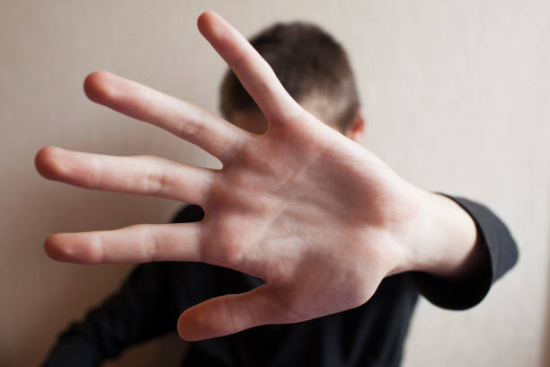 istock Teen boy protects himself with open palm 1145627498