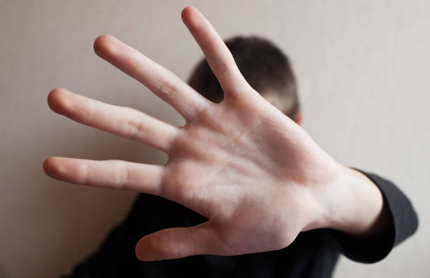istock Teen boy protects himself with open palm 1145627509