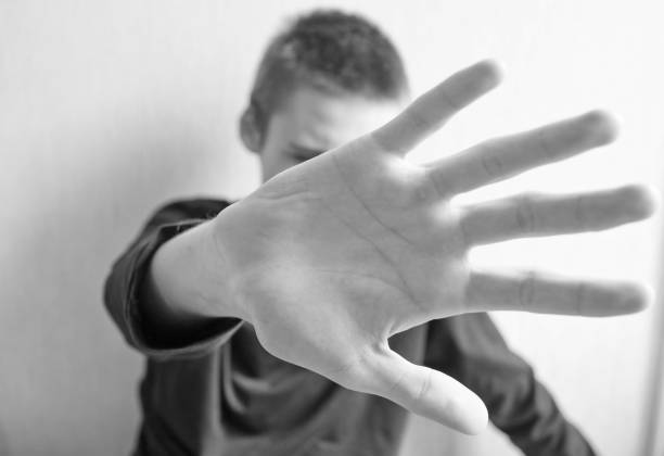 istock Teen boy protects himself with open palm 1145628042