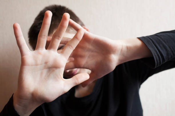 istock Teen boy protects himself with open palm 1145628053