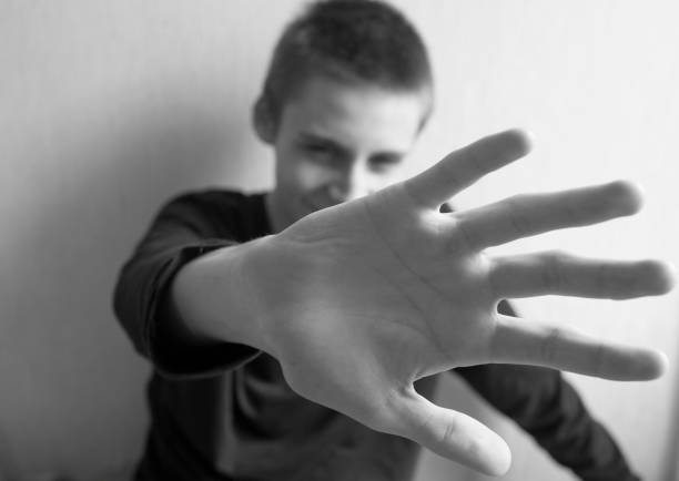 istock Teen boy protects himself with open palm 1145628137