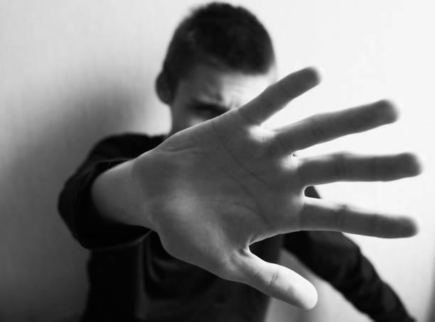 istock Teen boy protects himself with open palm 1145628166