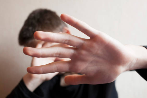 istock Teen boy protects himself with open palm 1145628174
