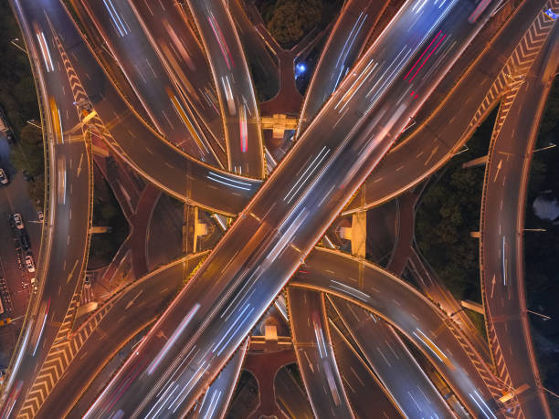 aerial view of highway junctions shape letter x cross at night with fog. bridges, roads, or streets in transportation concept. structure shapes of architecture in urban city, shanghai downtown, china. - road top view imagens e fotografias de stock