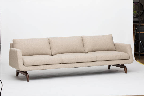istock Comfortable Cream colour three seater wooden sofa with white background 1145629231