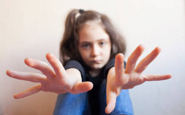 Little girl protects herself with her hand