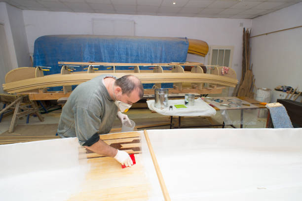 istock Carpenter insulating wooden canoe 1145632366
