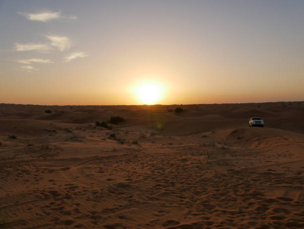 istock Setting sun on an evening in the desert with safari car 1145634874