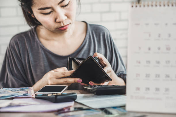 istock stress Asian woman open empty wallet looking for money for debt 1145635351