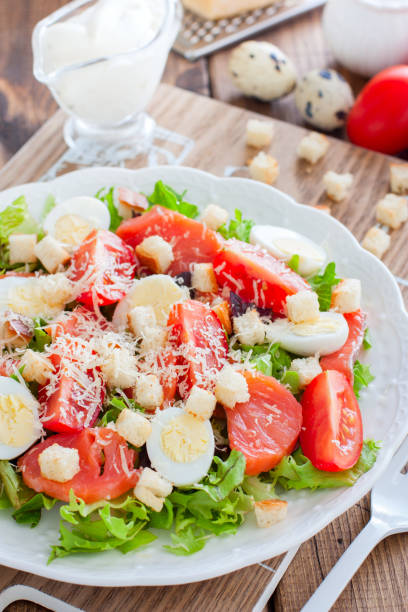 istock Caesar salad with salted salmon on a white plate, selective focus 1145639144
