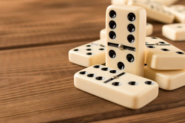 istock Playing dominoes on a wooden table. Domino effect. 1145639921