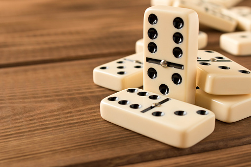 Playing dominoes on a wooden table. Domino effect