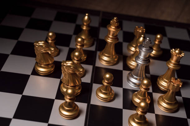 istock Close up shot chess on the board game with dark mood and tone process competition concept 1145642479