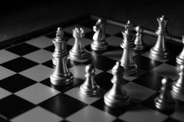 istock Close up shot chess on the board game with dark mood and tone process competition concept 1145642499