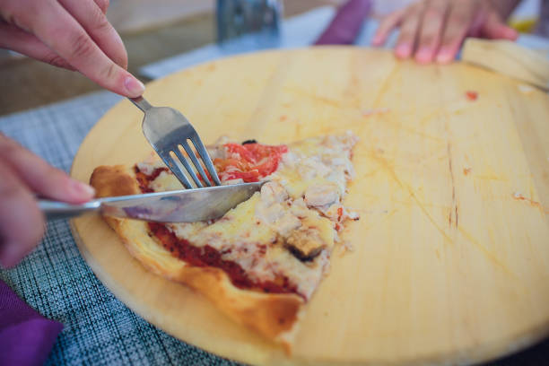 istock Hands taking pizza slices from wooden background. 1145643838