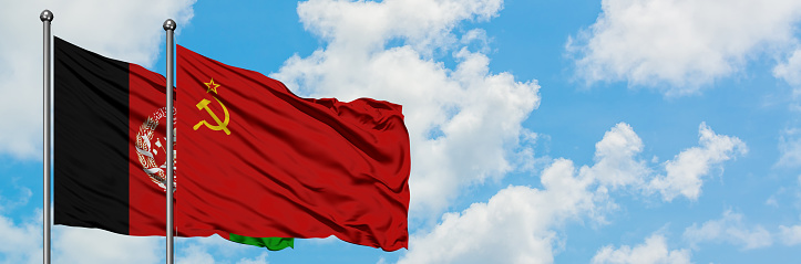 Afghanistan and Soviet Union flag waving in the wind against white cloudy blue sky together. Diplomacy concept, international relations.