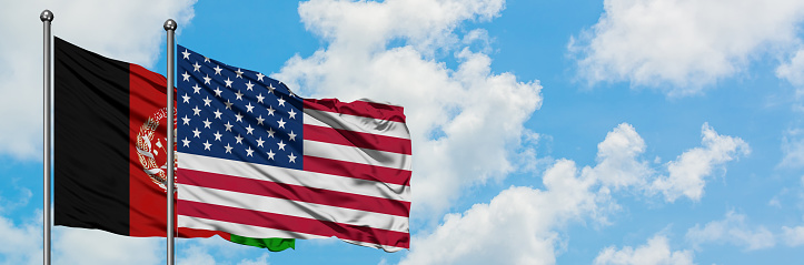 Afghanistan and United States flag waving in the wind against white cloudy blue sky together. Diplomacy concept, international relations.