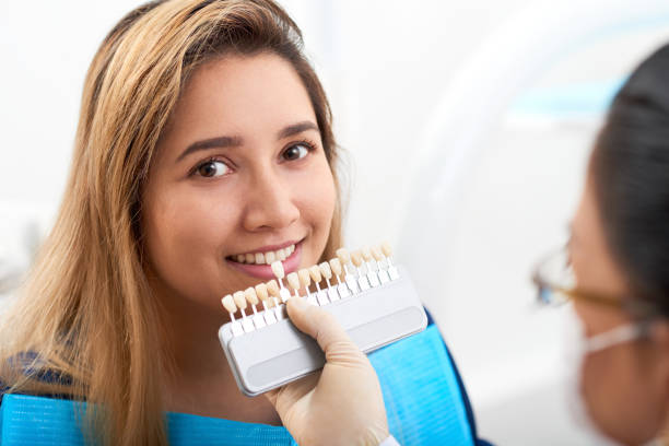 Young woman visiting doctor for teeth whitening Pretty smiling young Asian woman having teeth whitening procedure porcelain face stock pictures, royalty-free photos & images