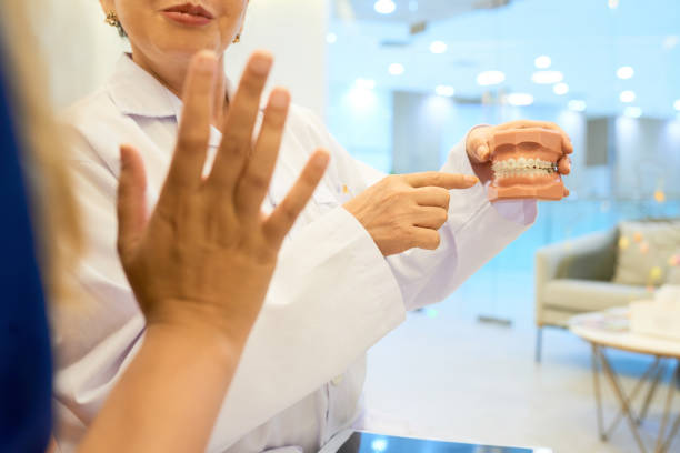 istock Orthodontist showing jaw to patient 1145647198