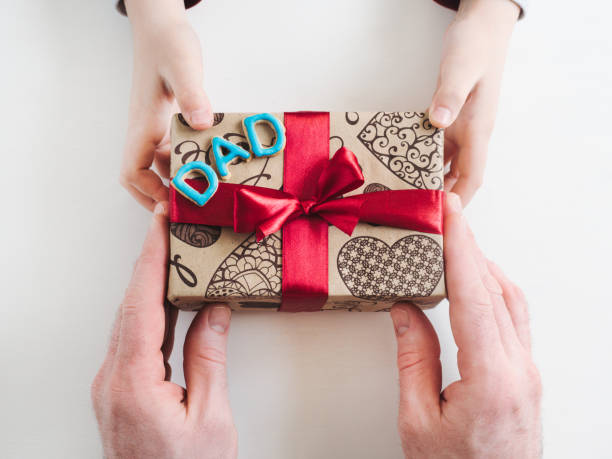 istock Child congratulating his Father. Preparing for the holidays 1145652940