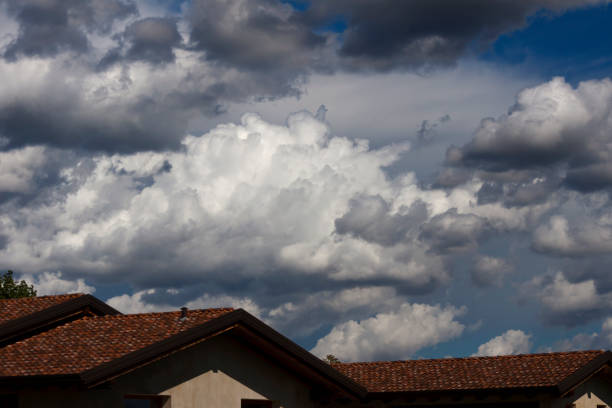 Stormy clouds in the sky, over the roofs of some homes - photograph stock photo