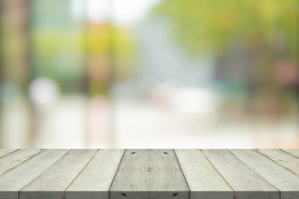 istock Empty wood table top on green blur background at shopping mall 1145654702