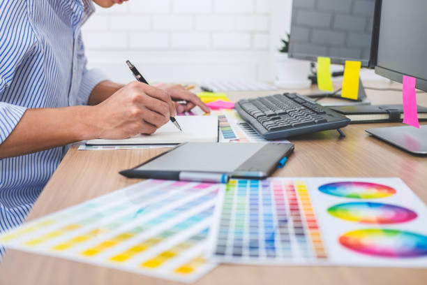 istock Image of male creative graphic designer working on color selection and drawing on graphics tablet at workplace with work tools and accessories in workspace 1145655953