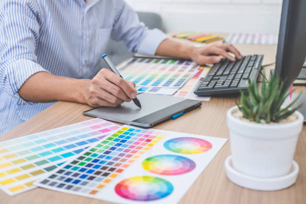 istock Image of male creative graphic designer working on color selection and drawing on graphics tablet at workplace with work tools and accessories in workspace 1145655961