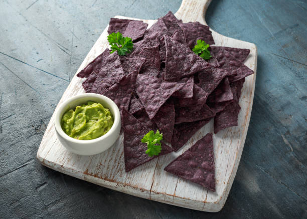 istock Blue corn Organic tortilla chips with Guacamole on white wooden board 1145658369