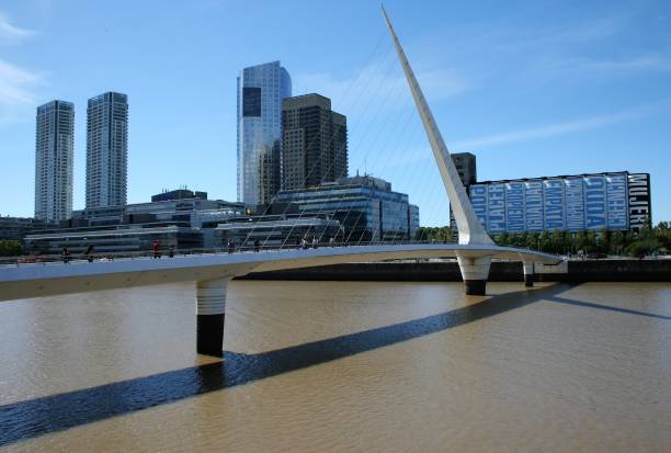 Women's Bridge Puerto Madero - Buenos Aires - Argentina - April 17, 2019. People walking along Puente de la Mujer in Puerto Madero with skyscrapers in the background. puente de la mujer stock pictures, royalty-free photos & images