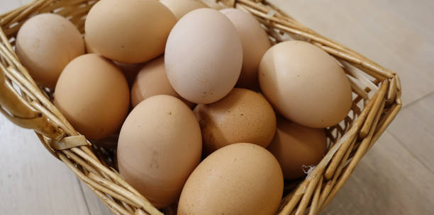 istock Chicken eggs in a basket on a wooden floor. Close-up 1145661506