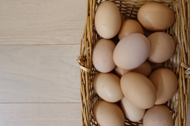 istock Chicken eggs in a basket on a wooden floor. Close-up 1145661511