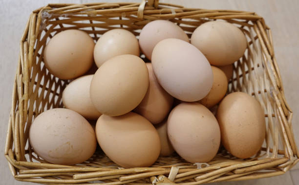 istock Chicken eggs in a basket on a wooden floor. Close-up 1145661522