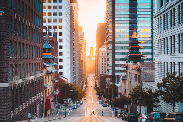 Downtown San Francisco with California Street at sunrise, San Francisco, California, USA Beautiful view of downtown San Francisco with famous California Street illuminated in first golden morning light at sunrise in summer, San Francisco, California, USA san francisco california street stock pictures, royalty-free photos & images