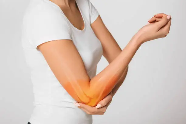 Photo of woman suffering pain in the elbow. Composite of image arm bones and elbow